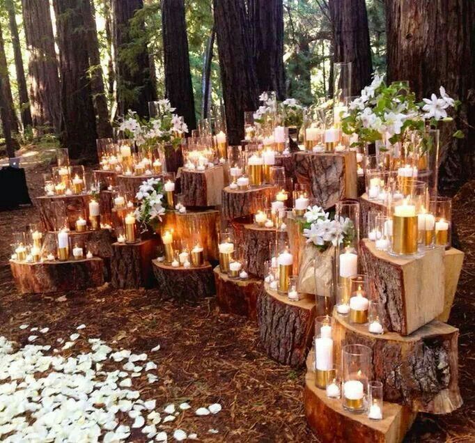 Chunks of tree trunks stacked with candles and flowers on it